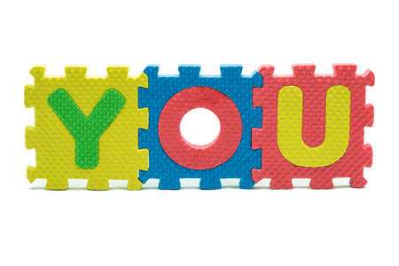 word YOU formed with colorful foam puzzle toy isolated on white blackgroundの写真素材