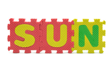 word SUN formed with colorful foam puzzle toy isolated on white blackgroundの写真素材