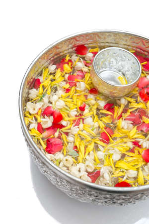 Water in bowl mixed with perfume and vivid flowers corolla for Songkran festival in Thailand の写真素材