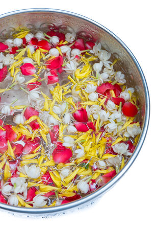 Water in bowl mixed with perfume and vivid flowers corolla for Songkran festival in Thailand の写真素材