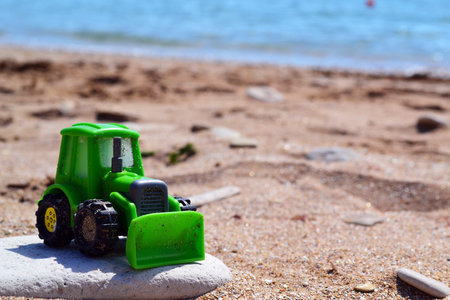 Kid green excavator at the beach