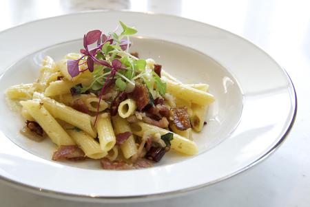 Penne with garlic and oil aglio e olio on white plateの写真素材