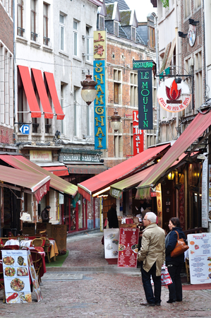 A couple decided what to eat in front of small alley with many restaurants in Brussels, Belgiumのeditorial素材