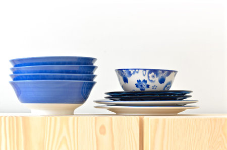 Blue and white dishes, plate and bowl on the cupboard at home.