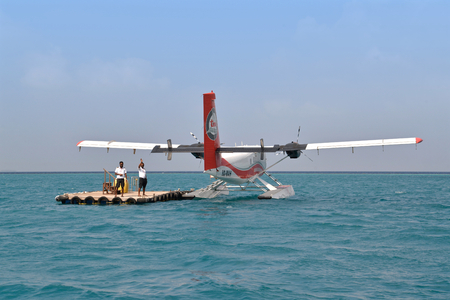After seaplane drop passengers off at the floating platform, crews are waving at the passengers who are leaving on the boat to the island.のeditorial素材