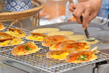 Thai crispy pancakes are sold along the street at Chinese New Year festival 2016 event, Yaowarat road, Bangkok, Thailand.のeditorial素材