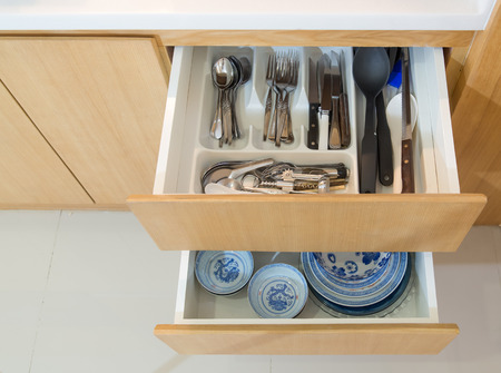 Open drawer with cutlery and dishware in the kitchenの写真素材