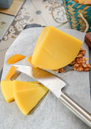 Edam cheese with knife and dried fruit and walnutの写真素材