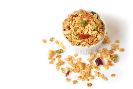 Homemade granola with honey, oatmeal, nuts, raisin and cranberry on white background - isolatedの写真素材