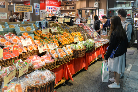 Tourists are looking at variety of local fruit stall at Kuromon Ichiba market, Nipponbashi, Osaka, Japanのeditorial素材