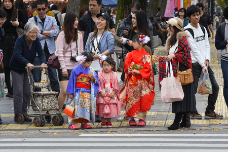 Girls in Kimono dress and many people are waiting to cross the street near Himeji Castle, Hyogo, Japanのeditorial素材