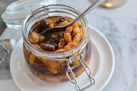 Raisin compote in glass jars with spoonの写真素材