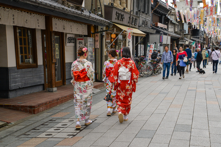 Kawagoe, Japan - May 14, 2017: Women dressing in Kimono are walking along shops and stores in Kawagoe with the street decorated with Koinobori for children day, Kawagoe, Japanyのeditorial素材
