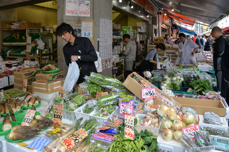 Tokyo, Japan - May 16, 2017: A man is selling variety of vegetables and fruit along the street at Tsukiji fish market, Tokyo, Japanのeditorial素材