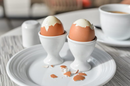 Boiled eggs in egg cup on a white plateの写真素材