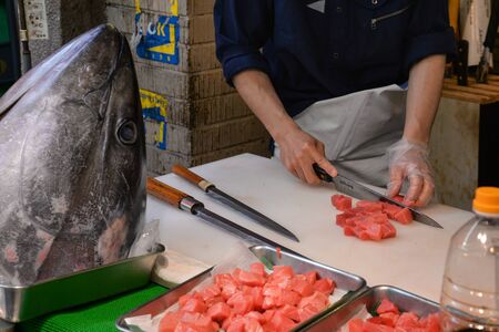 Tokyo, Japan - May 16, 2017: A man is cutting raw tuna, Otoro, along the street at Tsukiji fish market, Tokyo, Japanのeditorial素材