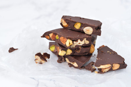 Dark chocolate bark with mixed nuts on wax paperの写真素材
