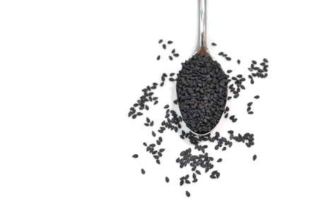 Black sesame in a spoon on white background - isolatedの写真素材