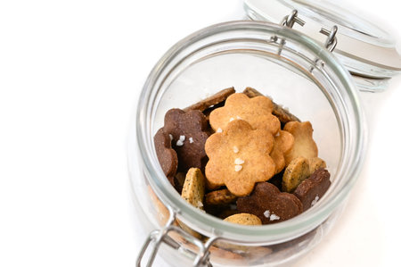 Homemade small cookies in a glass jar on white background - isolated