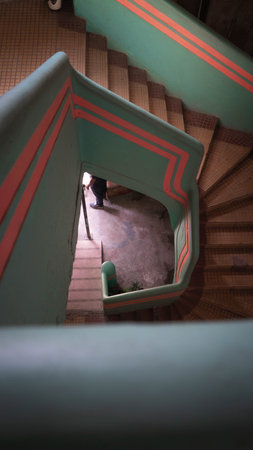 Stairwell seen from above in cyan, blue and salmon, pink colors with interesting pattern of shapes and shadowsの写真素材