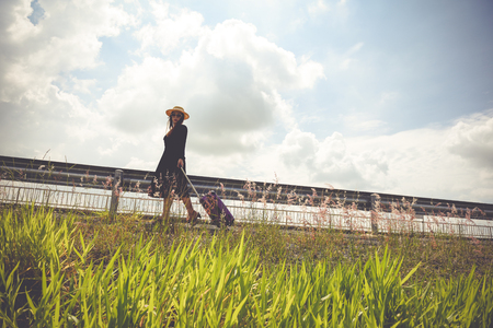 Women dressed in black with purple travel wallet,Traveling by road.の写真素材