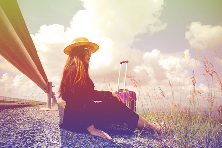 Women dressed in black with purple travel wallet,Traveling by road.の写真素材