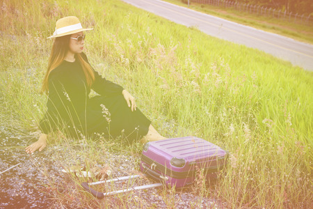 Women dressed in black with purple travel wallet,Traveling by road.の写真素材