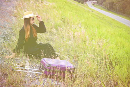 Women dressed in black with purple travel wallet,Traveling by road.の写真素材