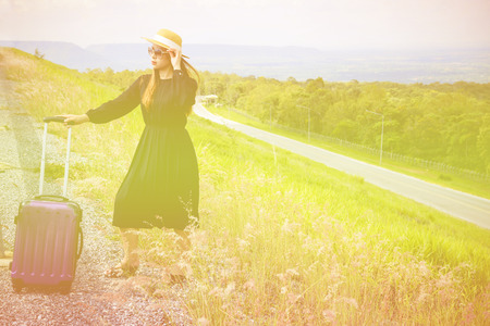 Women dressed in black with purple travel wallet,Traveling by road.の写真素材