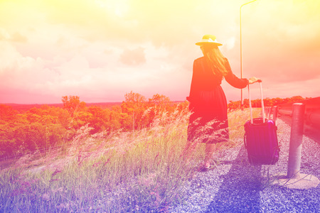 Women dressed in black with purple travel wallet,Traveling by road.の写真素材