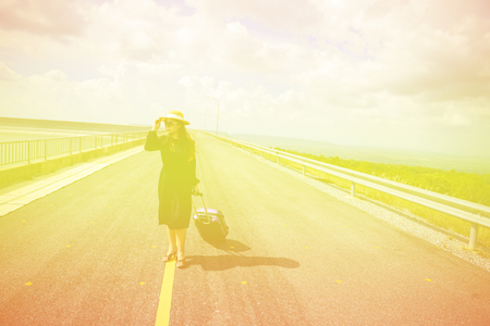 Women dressed in black with purple travel wallet,Traveling by road.の写真素材