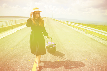 Women dressed in black with purple travel wallet,Traveling by road.の写真素材
