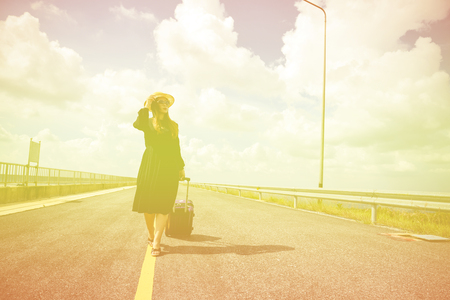 Women dressed in black with purple travel wallet,Traveling by road.の写真素材