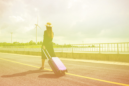 Women dressed in black with purple travel wallet,Traveling by road.の写真素材