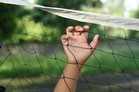 Hands with rope mesh fenceの写真素材