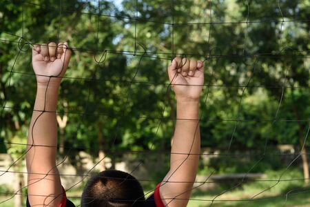 Hands with rope mesh fenceの写真素材