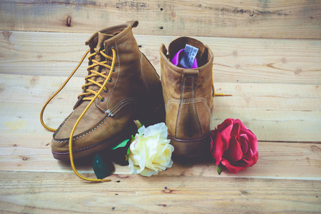 Old shoes and flower on a wooden background.Vintage Conceptの写真素材