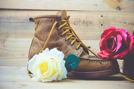 Old shoes and flower on a wooden background.Vintage Conceptの写真素材