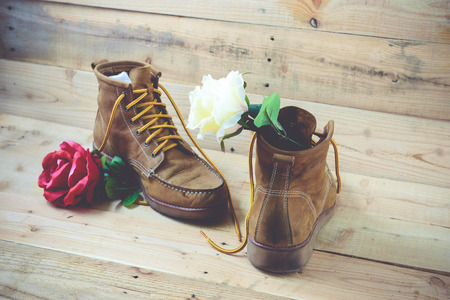 Old shoes and flower on a wooden background.Vintage Conceptの写真素材