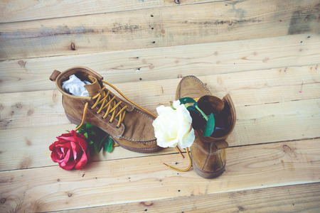 Old shoes and flower on a wooden background.Vintage Conceptの写真素材