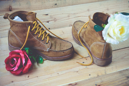Old shoes and flower on a wooden background.Vintage Conceptの写真素材