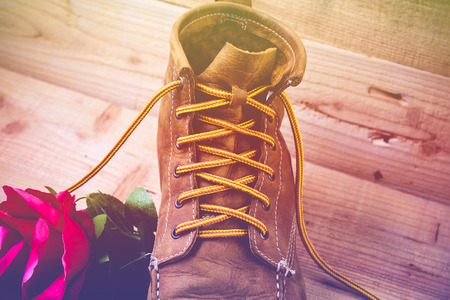 Old shoes and flower on a wooden background.Vintage Conceptの写真素材