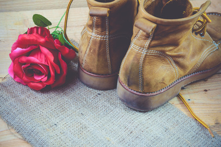 Old shoes and flower on a wooden background.Vintage Conceptの写真素材