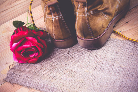 Old shoes and flower on a wooden background.Vintage Conceptの写真素材