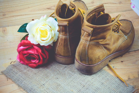 Old shoes and flower on a wooden background.Vintage Conceptの写真素材