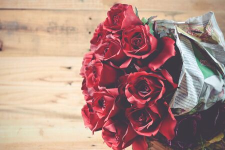 A bouquet of red roses on a wooden background.の写真素材