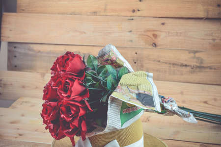 A bouquet of red roses on a wooden .の写真素材