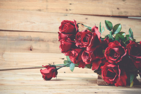 A bouquet of red roses on a wooden .の写真素材