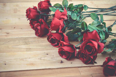 A bouquet of red roses on a wooden .の写真素材