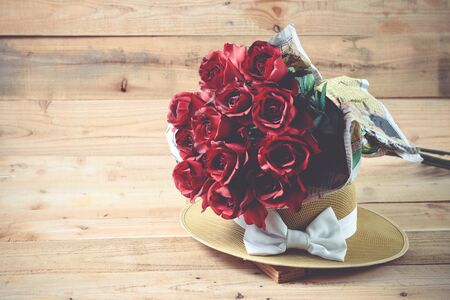 A bouquet of red roses on a wooden .の写真素材